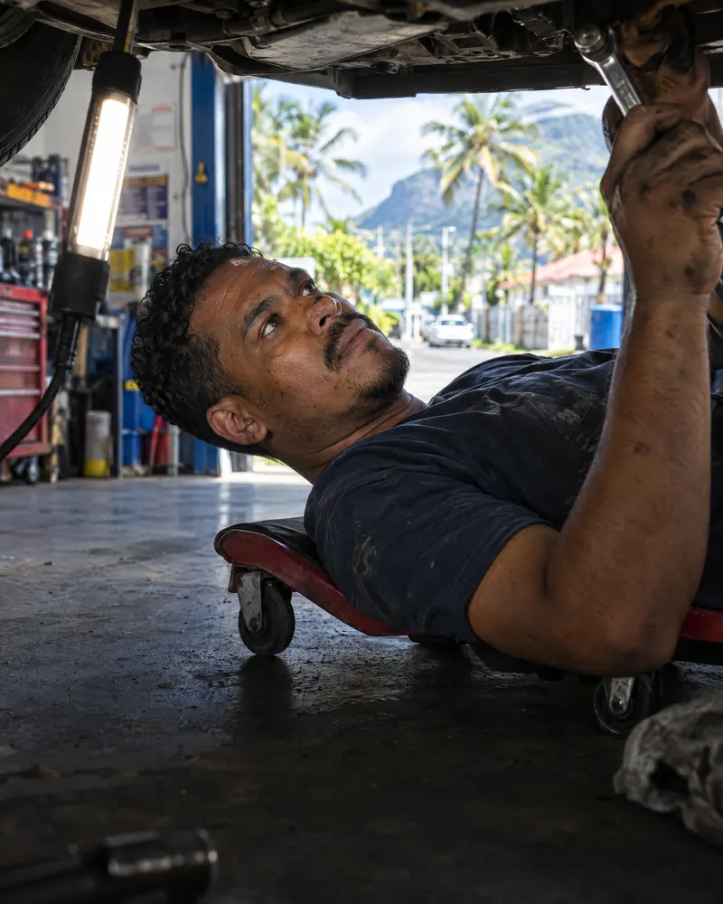 Mécanicien allongé sous une voiture dans son garage